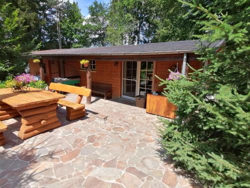 a patio with a bench and a cabin at Authentic chalet in Wibrin with private fish pond in Wibrin