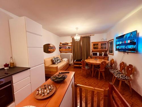 a kitchen and living room with a table and a dining room at La Baita Limone Riserva Bianca Ski-in Ski-out Seggiovia Morel 3 in Limone Piemonte