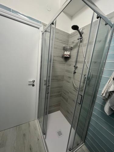 una doccia con una porta in vetro in un bagno di Una notte sul colle a Recanati
