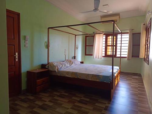 een slaapkamer met een hemelbed in een kamer bij Villa privée avec garden à bord de plage in Cotonou