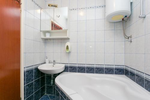 a bathroom with a sink and a tub and a toilet at Apartment Seget Vranjica 1038b in Seget Vranjica