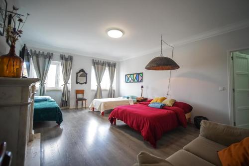 a bedroom with two beds and a couch at Aquarela do Tejo Guesthouse in Vila Franca de Xira