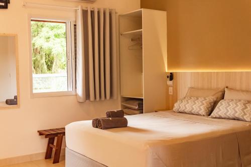 a bedroom with a large bed with a window at Solarium Flats Itagua - Ubatuba SP in Ubatuba