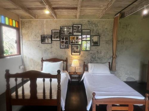 two beds in a bedroom with pictures on the wall at LEJU 21 樂居 Explore Malacca from a riverside house in Melaka