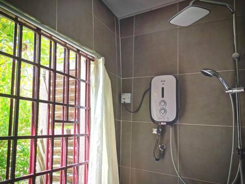 a shower in a bathroom next to a window at LEJU 21 樂居 Explore Malacca from a riverside house in Malacca