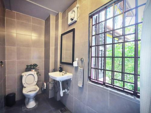 a bathroom with a toilet and a sink and a window at LEJU 21 樂居 Explore Malacca from a riverside house in Melaka