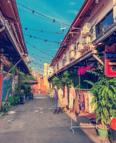 a group of people walking down a street with buildings at LEJU 21 樂居 Explore Malacca from a riverside house in Melaka