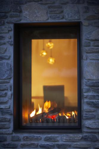 a fireplace in a brick wall with a fire in it at Europe Hotel & Spa in Zermatt