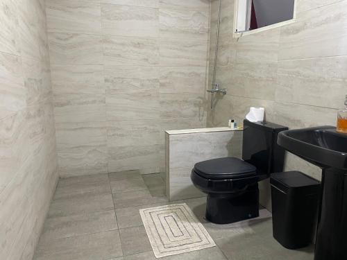 a bathroom with a black toilet and a sink at Dormitorio privado con desayuno incluido in Asuncion