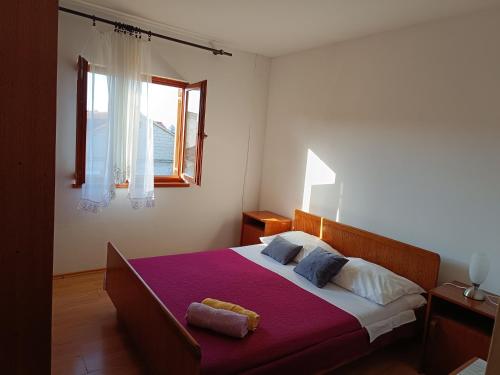 ビビニェにあるApartments by the sea Bibinje, Zadar - 5780のベッドルーム(紫の毛布を使用した大型ベッド1台付)
