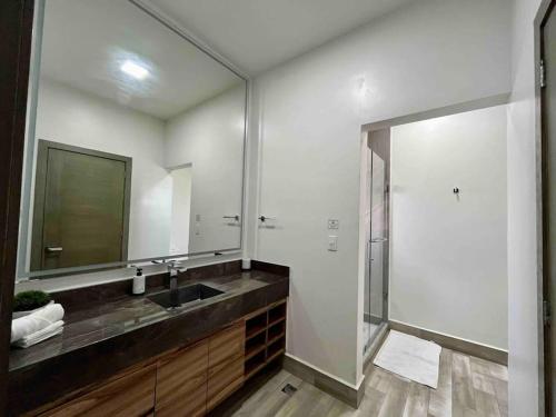 y baño con lavabo y ducha con espejo. en Amplia casa de 5 habitaciones, estilo, confort y diseño único garantizados, en Monterrey