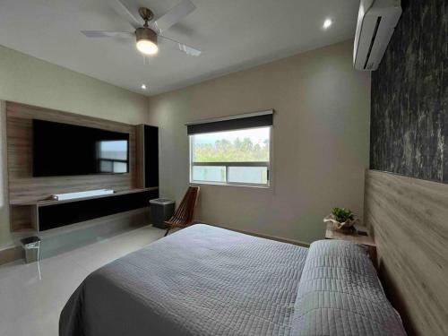 1 dormitorio con 1 cama y TV de pantalla plana en Amplia casa de 5 habitaciones, estilo, confort y diseño único garantizados, en Monterrey