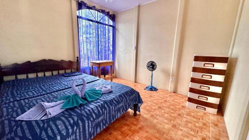 a bedroom with a bed with a dresser and a window at El Manantial de Corcovado in Dos Brazos