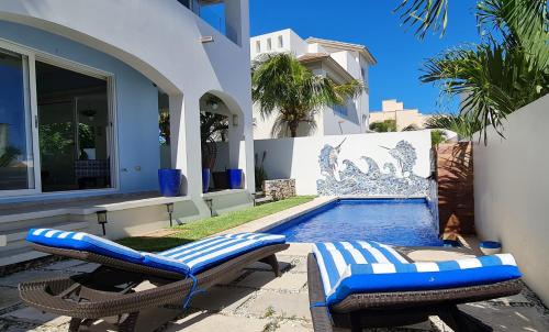 a swimming pool with two lounge chairs next to a house at CASA REYES Stunning Rooftop Oceanview in Isla Mujeres