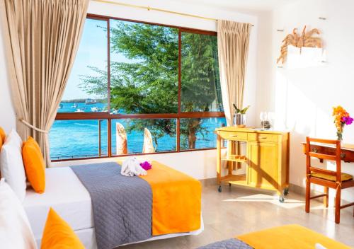 um quarto com uma cama e uma grande janela em La Zayapa Hotel em Puerto Baquerizo Moreno