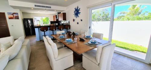 a dining room with a wooden table and white chairs at CASA REYES Stunning Rooftop Oceanview in Isla Mujeres
