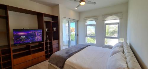 una camera da letto con un letto e una TV a schermo piatto di CASA REYES Stunning Rooftop Oceanview a Isla Mujeres