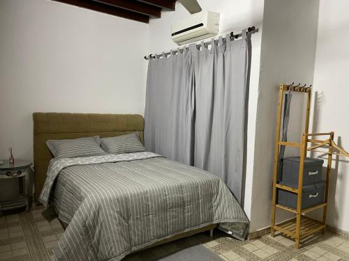 a bedroom with a bed and a television on the wall at Dormitorio privado con desayuno incluido in Asuncion