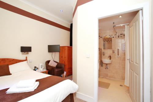 a bedroom with a bed and a bathroom with a shower at CitiHouse Aberdeen West End in Aberdeen