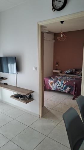 a bedroom with a bed and a tv and chairs at La Kay Cassi in Saint-Pierre