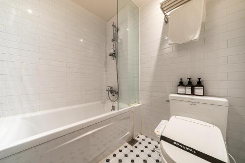 a bathroom with a toilet and a tub and a sink at Yangju Hotel NO25 