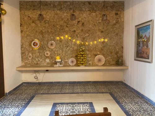 una camera con una parete in pietra, un tavolo e un bancone di Boutique Casa Azuli Santiago a Mérida