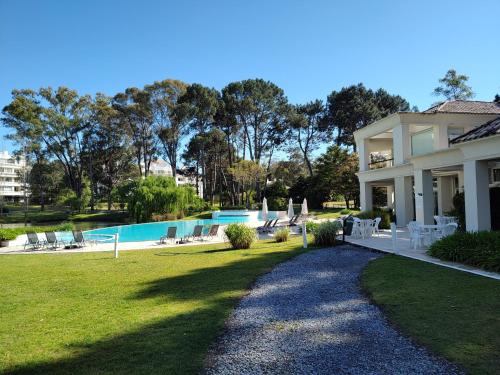 ein Haus mit einem Garten mit Pool in der Unterkunft Green Park Punta del Este in Punta del Este