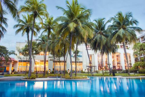 a hotel with palm trees in front of it at Bangi Resort Hotel in Bangi