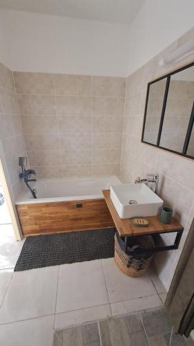 a bathroom with a bath tub and a sink at La Kay Jade in Saint-Pierre