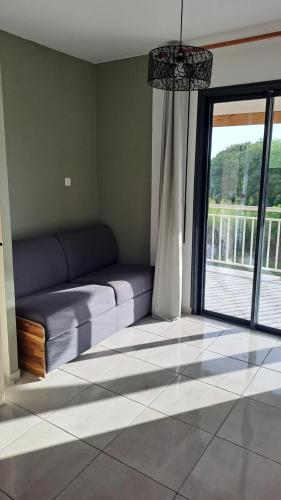 a living room with a couch and a large window at La Kay Jade in Saint-Pierre