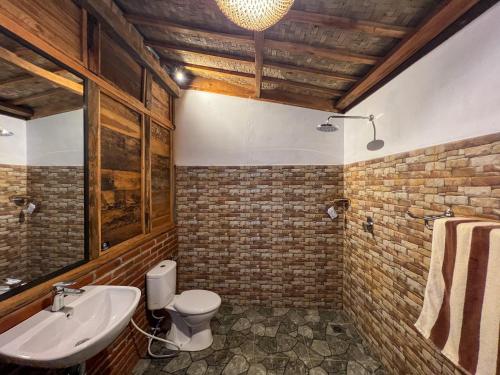 La salle de bains est pourvue de toilettes blanches et d'un lavabo. dans l'établissement Melasti Mountain Villas, Amed, Room 3 Agung Guesthouse, à Amed