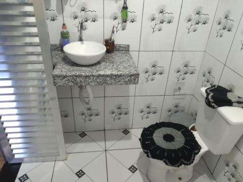 La salle de bains blanche est pourvue d'un lavabo et de toilettes. dans l'établissement Casa da teka, à Pedro de Toledo