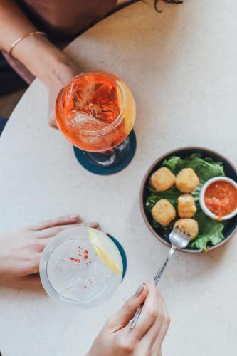 a person sitting at a table with a bowl of food and a drink at Plaza Real Suites Hotel in Rosario