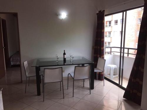einen Esstisch mit Stühlen und eine Flasche Wein in der Unterkunft Bueno y amplio apartamento en el barrio mas cool del Mundo , Laureles in Medellín