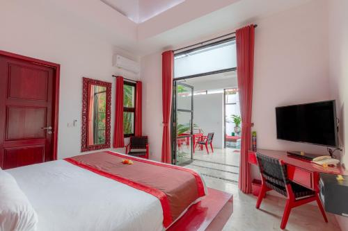 a bedroom with a bed and a desk with a television at Bali Ginger Suites & Villa in Seminyak