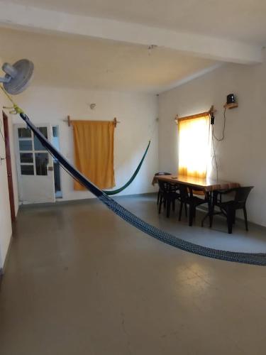 a hammock in a room with a table and a window at Ola Perfecta Hostel in Barra de la Cruz