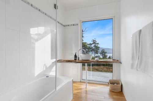 ein weißes Bad mit einer Dusche und einem Fenster in der Unterkunft Newhaven in Dover