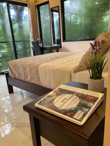 a room with a bed and a table with a book on it at Mountain Top Park Hotel in Quepos