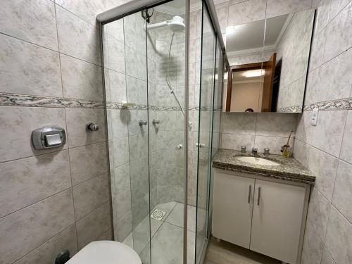 a bathroom with a shower and a toilet and a sink at Apto super luxo beira mar Capão da Canoa in Capão da Canoa