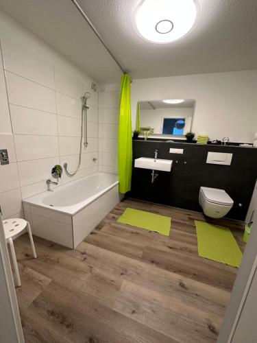 a bathroom with a tub and a sink and a toilet at Lissi Apartment nur 5 Min vom Europa Park und direkt am Naturschutzgebiet in Kappel-Grafenhausen
