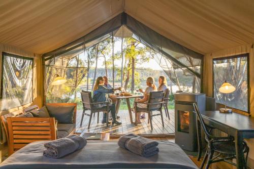 a group of people sitting at a table in a tent at Tanja Lagoon Camp in Tanja
