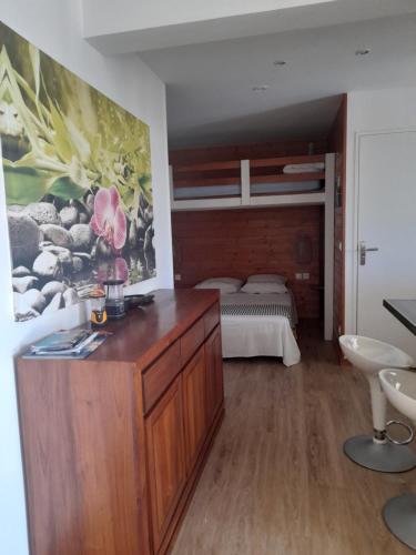 ein Schlafzimmer mit einer großen Holzkommode und einem Bett in der Unterkunft Lacréola in Saint-Joseph