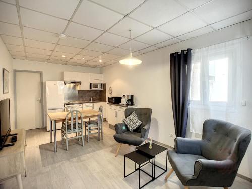 un salon avec une table et des chaises et une cuisine dans l'établissement Charmant F2 tout équipé, proche centre-ville et Thermes, avec Wifi, animaux acceptés - FR-1-451-173, à Lamalou-les-Bains