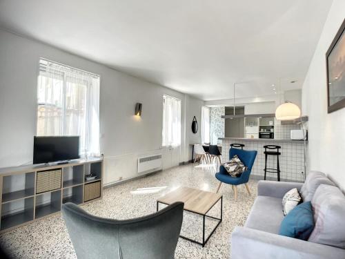 un salon avec un canapé et une télévision dans l'établissement Appartement F3 avec Terrasse, Proche Centre et Thermes, Animaux Acceptés - Lamalou-les-Bains - FR-1-451-174, à Lamalou-les-Bains
