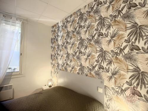 sypialnia z łóżkiem z tropikalną tapetą w obiekcie Appartement F3 avec Terrasse, Proche Centre et Thermes, Animaux Acceptés - Lamalou-les-Bains - FR-1-451-174 w mieście Lamalou-les-Bains