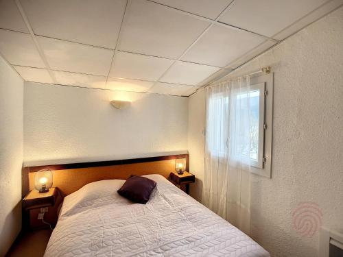 - une chambre avec un lit et deux lumières sur deux tables dans l'établissement Charmant T2 avec Wi-Fi, ascenseur, proche Thermes et centre-ville, idéal pour curistes, animaux acceptés - FR-1-451-178, à Lamalou-les-Bains