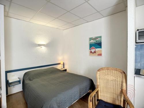 une petite pièce avec un lit et une chaise dans l'établissement Studio Cosy à Lamalou-les-Bains, Proche Centre et Thermes, Balcon, Wi-Fi, Animaux Bienvenus - FR-1-451-180, à Lamalou-les-Bains