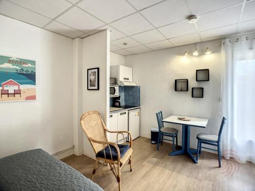 une chambre avec un lit, une table et des chaises dans l'établissement Studio Cosy à Lamalou-les-Bains, Proche Centre et Thermes, Balcon, Wi-Fi, Animaux Bienvenus - FR-1-451-180, à Lamalou-les-Bains