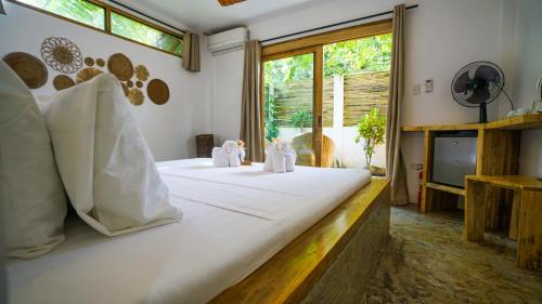 a bedroom with two white cats sitting on a bed at Serenity Hotel in El Nido