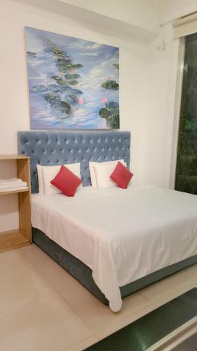 a bedroom with a large bed with red pillows at Lotus Colombo Guesthouse in Colombo